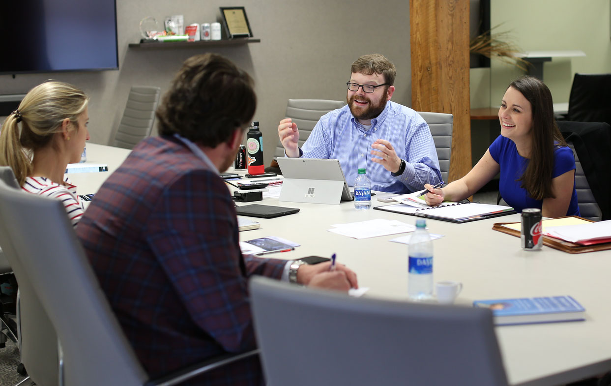 Four people meeting around a table.