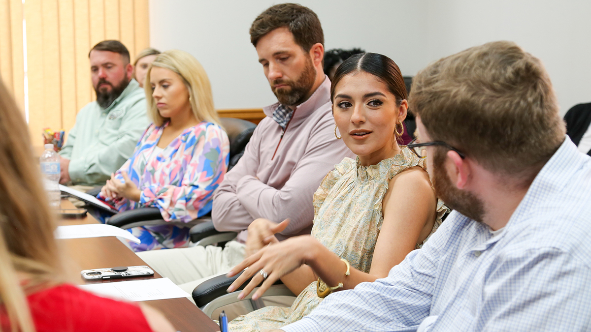 group of people sitting at a table talking